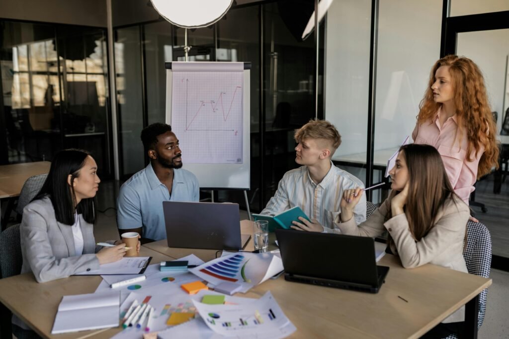 A diverse team discussing business strategy around a conference table in a modern office.